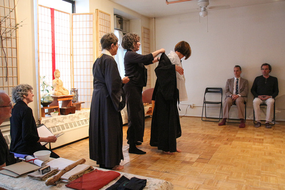 receiving the robes; Dharma Holder Jean assists Sensei Marisa